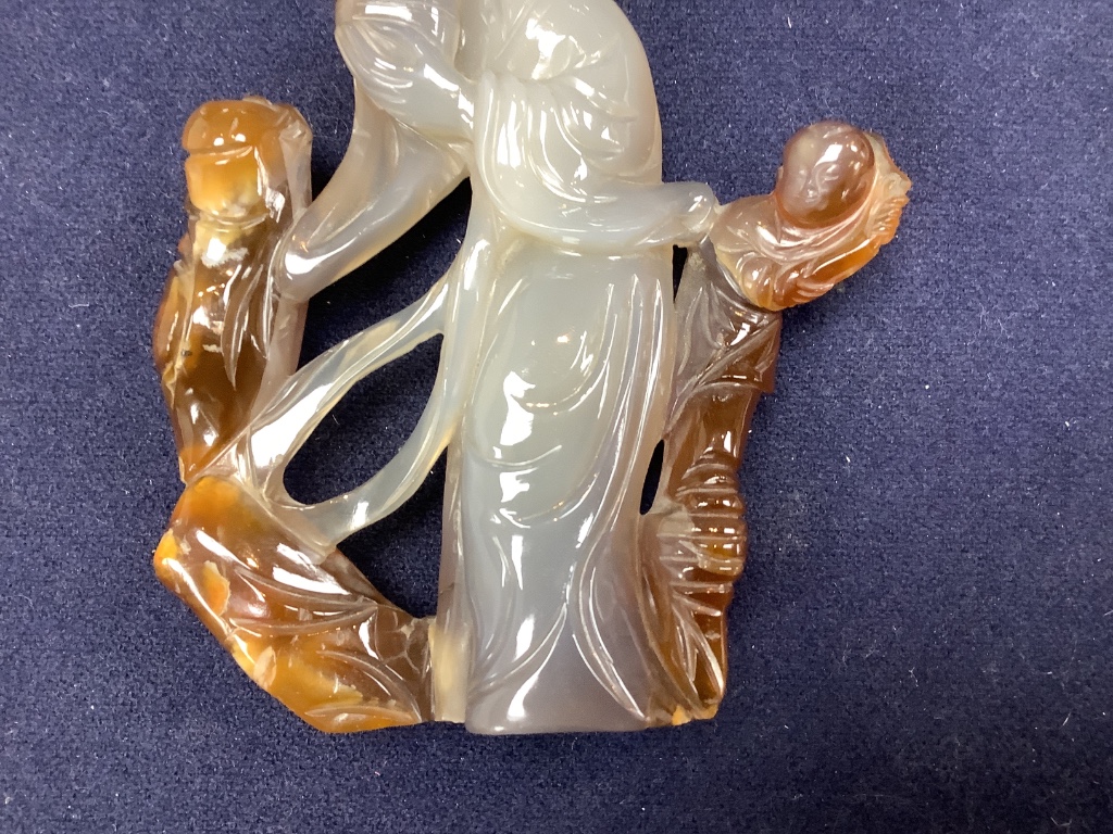 An early 20th century Chinese agate group of Guanyin and two boys, wood stand